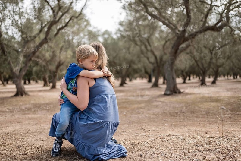 The boy in the arms of his mother in an olive grove