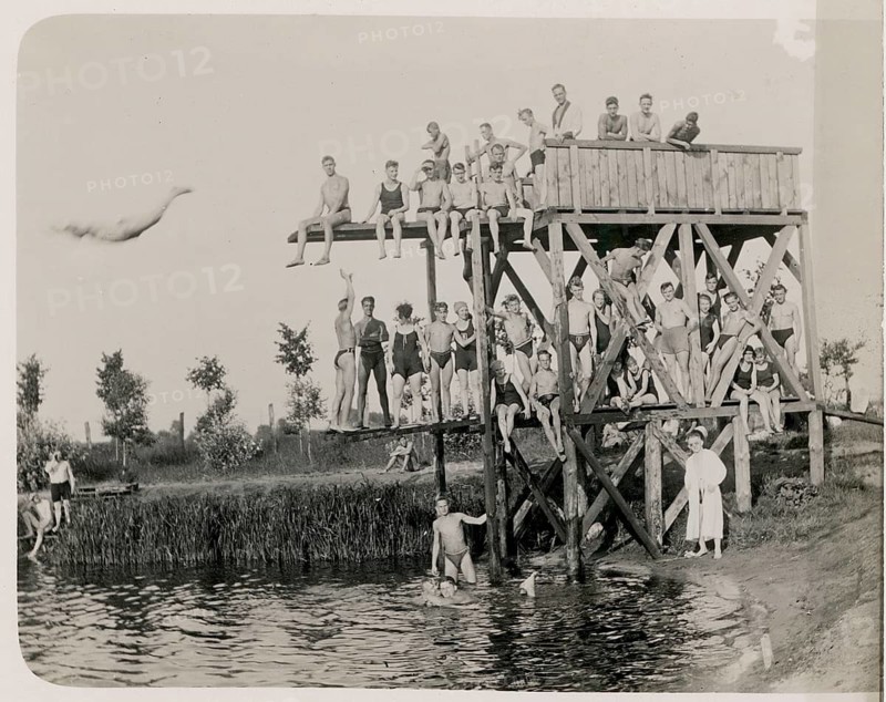 Outdoor pool, diving tower, bathing, swimwear, leisure, summer, woman, men, girls, boys, children, children standing on a wooden platform by the water and jumping into cool water, lake, around 1924