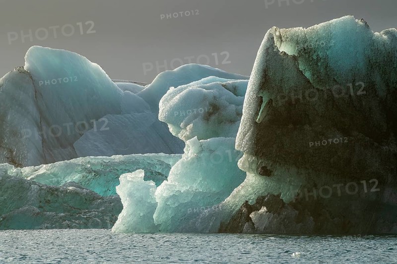 Turquoise-coloured icebergs rise out of the water, an imposing and dramatic backdrop, Jökulsárlón glacier lagoon or Jökulsarlon, South Iceland, Iceland