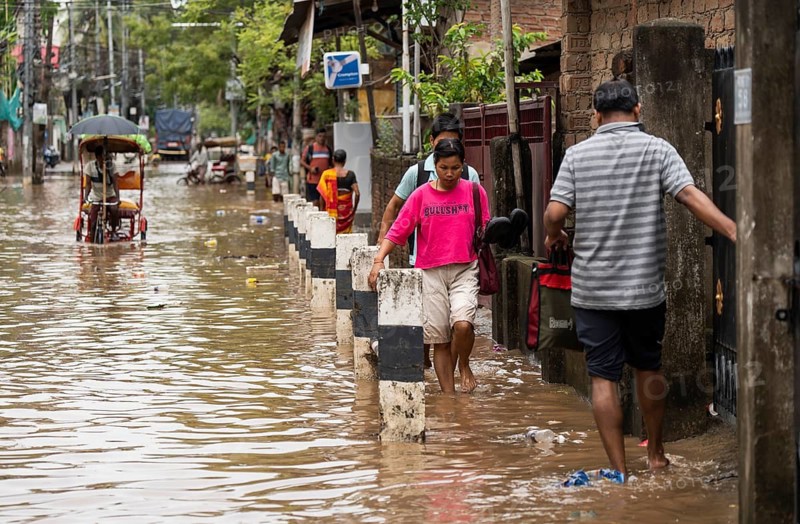 Commuters wade through a flooded street after heavy rains in Guwahati, India on April 28, 2025