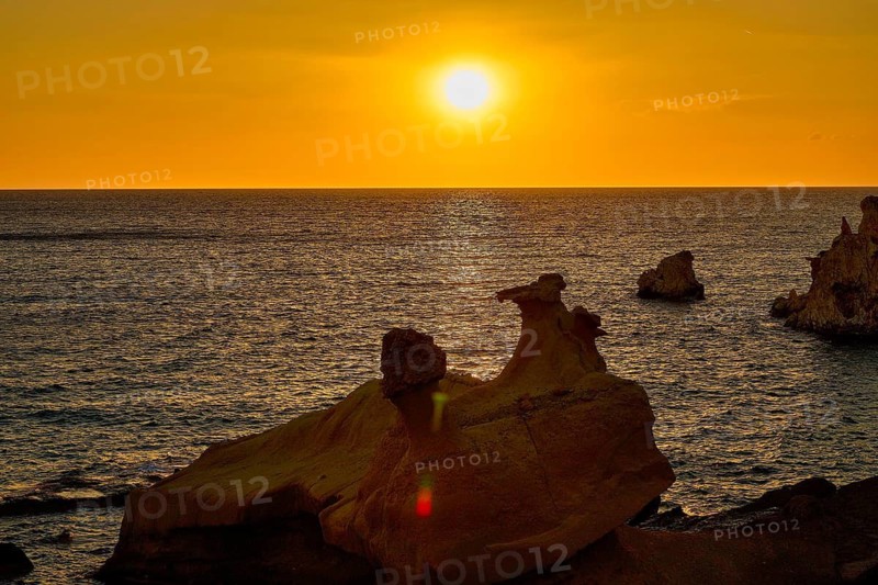 Sunset, sunny horizon over quiet lake with dark rocks in foreground, Aspragremna, white cliffs, Mavorspilia Beach, beach, Kimolos island, Cyclades, Greek Islands, Greece