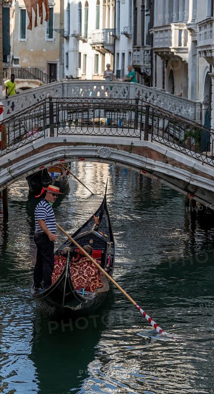 Gondolier on a Venetian gondola on the Rio di Palazzo canal, Venice, Veneto, Italy