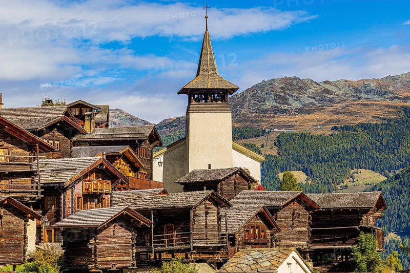 Old wooden houses and the Saint Theodule church in the historic village centre, Grimentz, Val d'Anniviers, Valais Alps, Canton Valais, Switzerland