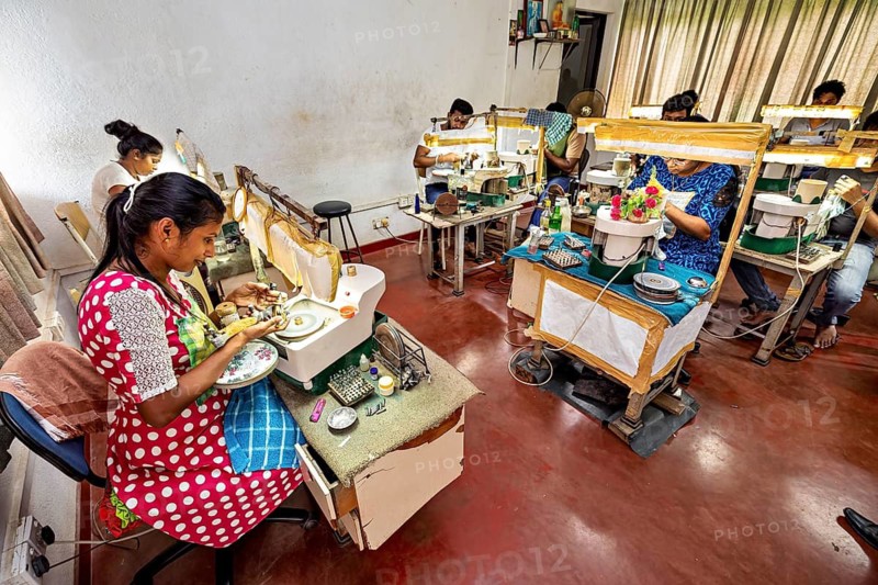 A room full of people concentrating on pieces of jewelry in an educational atmosphere, The sapphire and gemstone cutters at Ratnapura in Sri Lanka