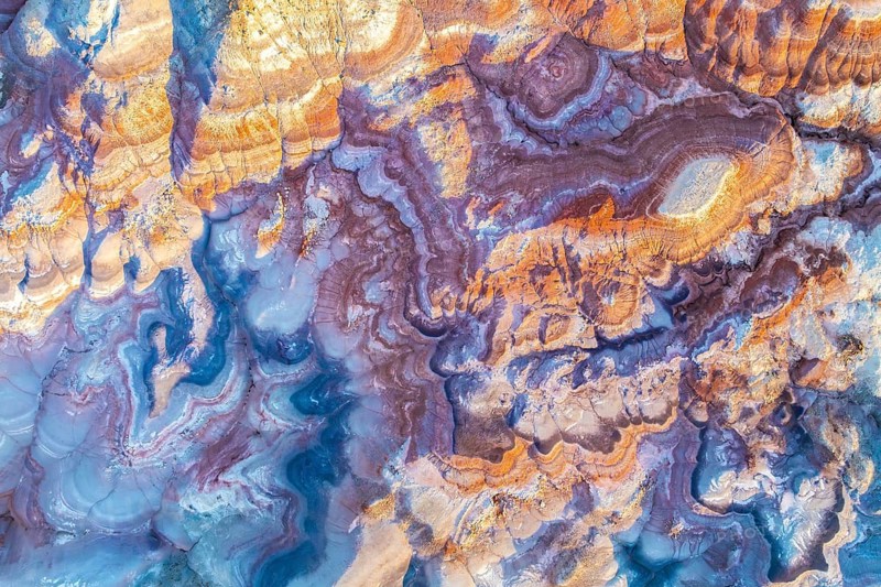 Aerial image showcasing the vivid colors and intricate patterns of bentonite clay formations in Utah, USA. The natural abstract artwork is a testament to geological beauty