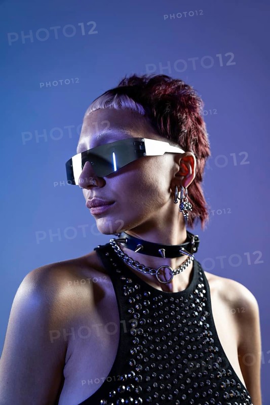 A striking portrait of a cyberpunk woman with edgy sunglasses, sporting bold accessories and a modern hairstyle against a cool-toned background, embodying futuristic style