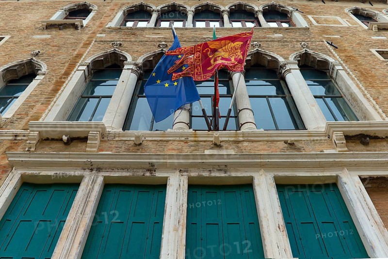 Facade of a palace with flags of Venice and Europe, Venice, Veneto, Italy