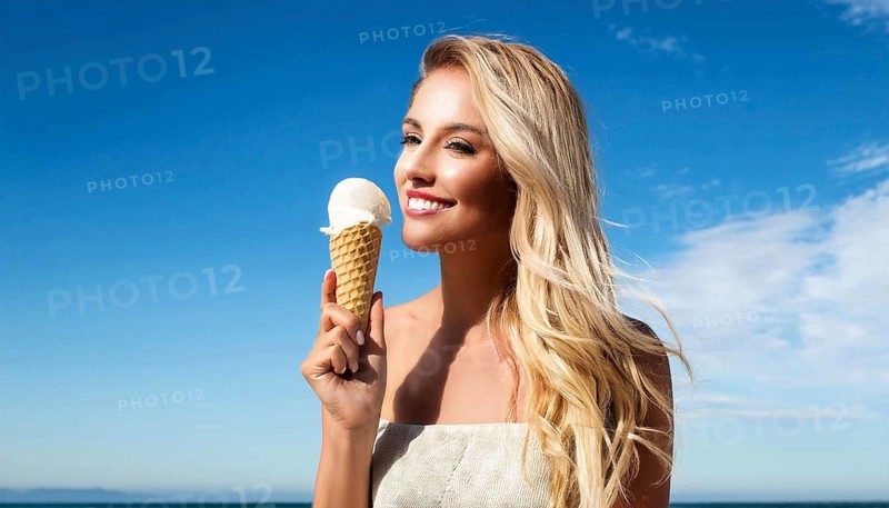 A blonde woman enjoys eating an ice cream in a cone