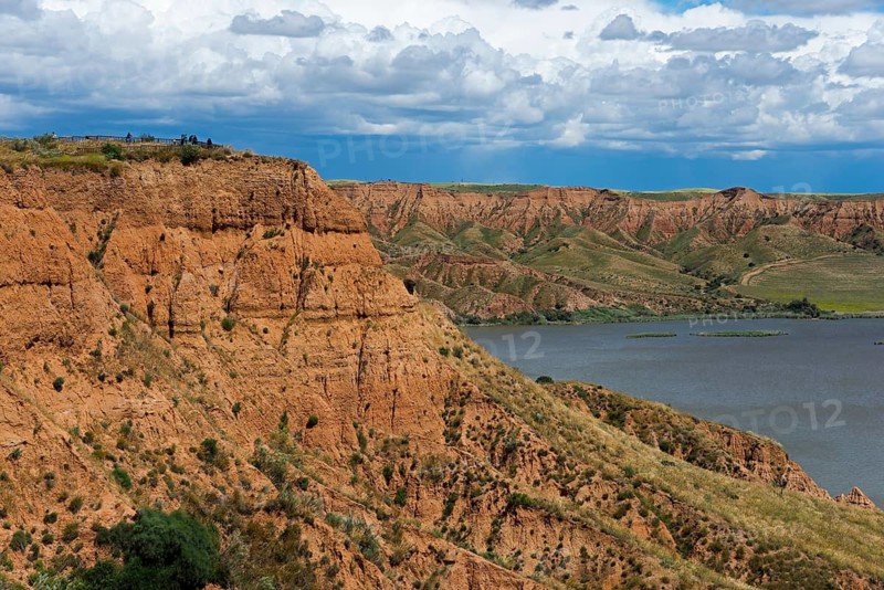 Ein felsiger Canyon, der sich an einem See mit dichtem grauen Himmel darüber erstreckt, Barrancas de Burujón, Burujon, río Tajo, Fluss Tajo, embalse de Castrejón, Stausee de Castrejon, Toledo, Kastilien-La Mancha, Spanien