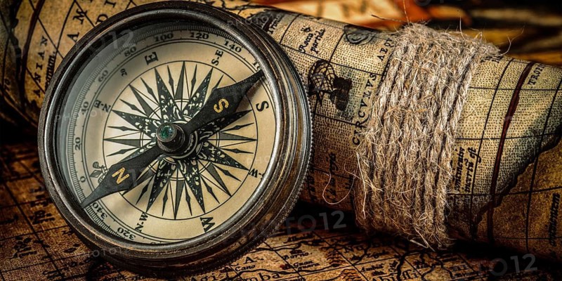 Travel geography navigation concept background, letterbox panorama of old vintage retro compass on ancient world map