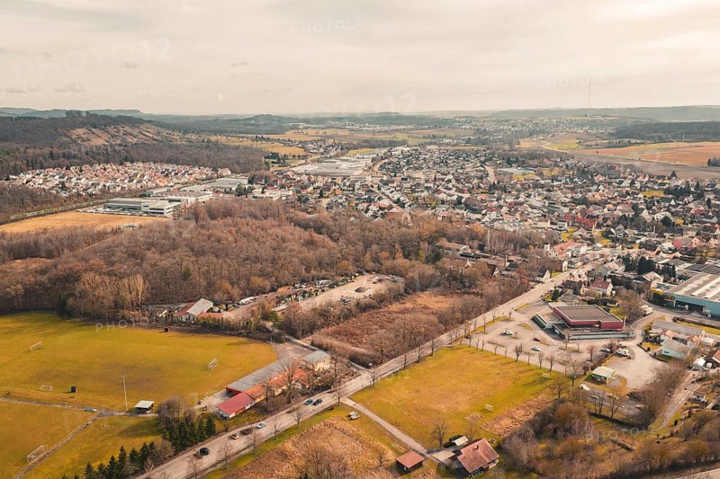 Village with winding roads surrounded by trees, fields and rolling hills under a cloudy sky, Ötisheim, Enzkreis, Germany