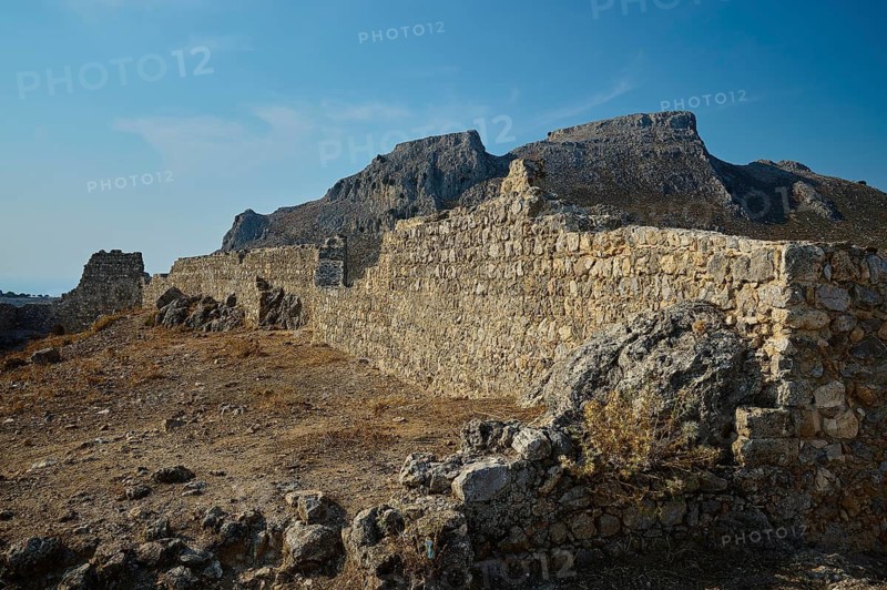 Stone ruins in an arid landscape with mountains in the background under a clear sky, fortress walls, St John's Castle, Archengelos village, Rhodes, Dodecanese, Greek Islands, Greece