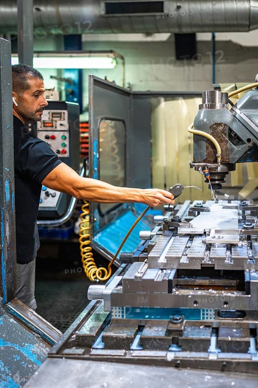 Male caucasian worker using electric milling machine in an innovative cnc metallurgic factory