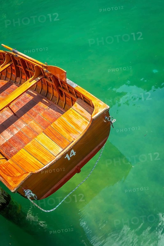 Classic wooden rowboat gently floating on the crystal clear emerald waters of lake braies, a picturesque destination in the dolomites