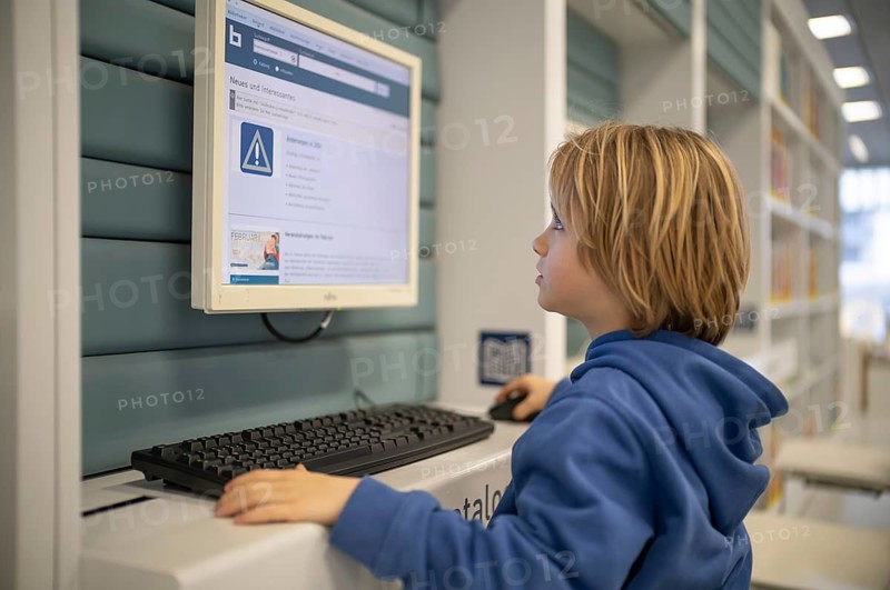 Interior shot, boy, 6 years old, blonde, operating computer, PC station, city library catalog, architect Eun Young Yi, Stuttgart, Baden-Württemberg, Germany