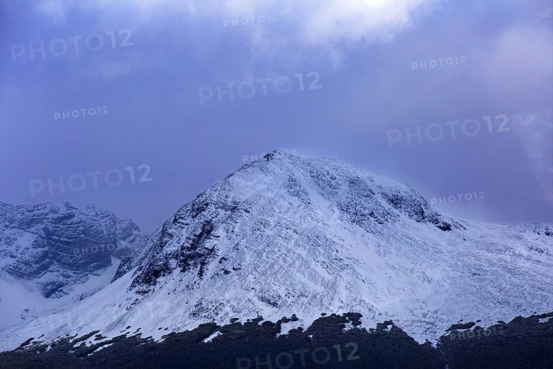 Single snow-covered mountain peak under a shady sky in Ushuaia, Ushuaia, Argentina