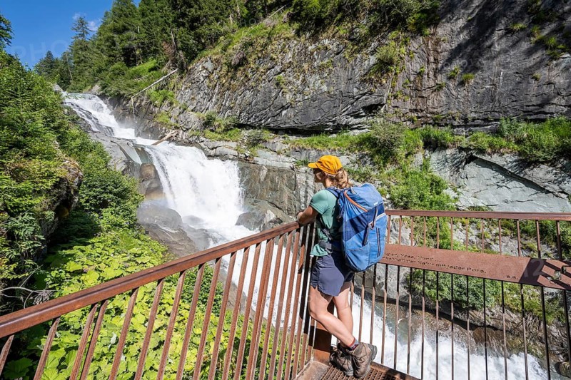 Hiker in front of waterfalls in Umbaltal, Hohe Tauern National Park, East Tyrol, Tyrol, Austria