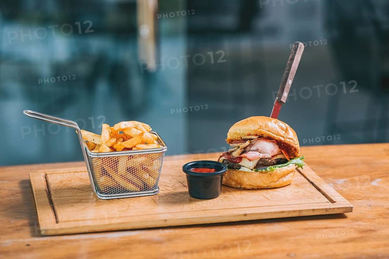 Delicious big burger with fries served on a restaurant table