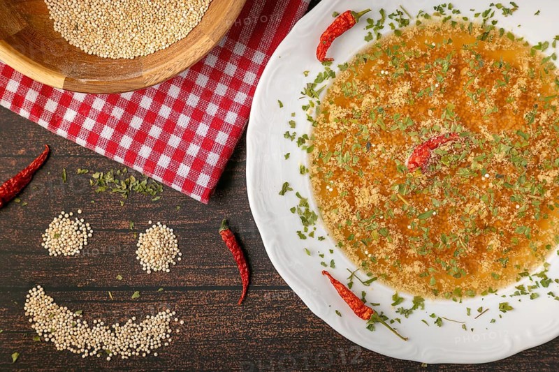 Decorated soup plate next to a smiling quinoa face on rustic table