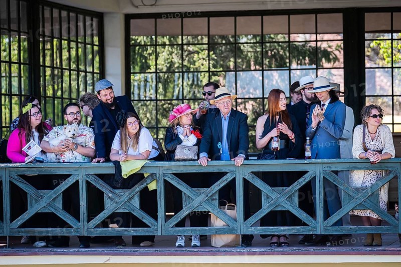 WROCLAW, POLAND - MAY 1, 2026: Horse race track WTWK Partynice. Crowd of elegant spectators wearing hats and formal clothes watching a horse race from a wooden gallery