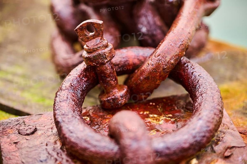 Old rusty chain on a wood at the harbor in Venice on a foggy morning in winter, Italy