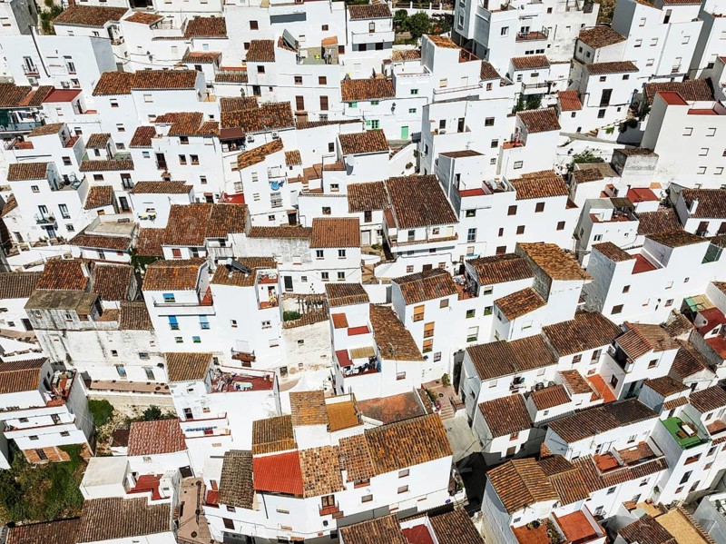 The brilliant White Town of Casares clings to a steep hillside. Aerial view. Drone shot. Málaga province, Andalusia, Spain