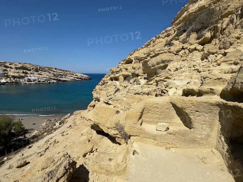 Partial view of former Roman necropolis with cave dwelling tombs carved in sandstone Grottoes in rocks on the north side of Matala Bay, in the 60s and 70s hippie caves Caves for dropouts and hippies today excursion destination on the south coast of Crete, left at the edge of the picture Libyan Sea Mediterranean, Matala, Crete, Greece