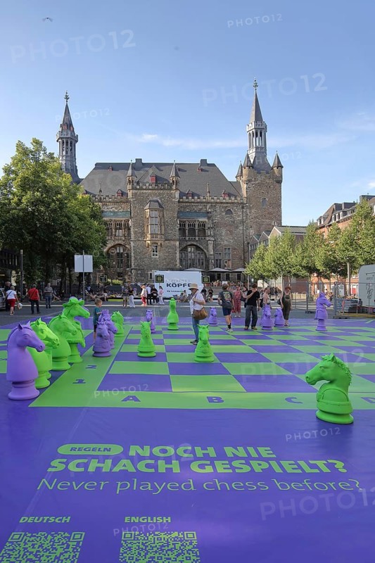 Chess game and playground at the Gothic town hall with square granus tower and round market tower, pedestrian zone, inscription, public chess board, chess pieces, old town, Aachen, Eifel, North Rhine-Westphalia, Germany