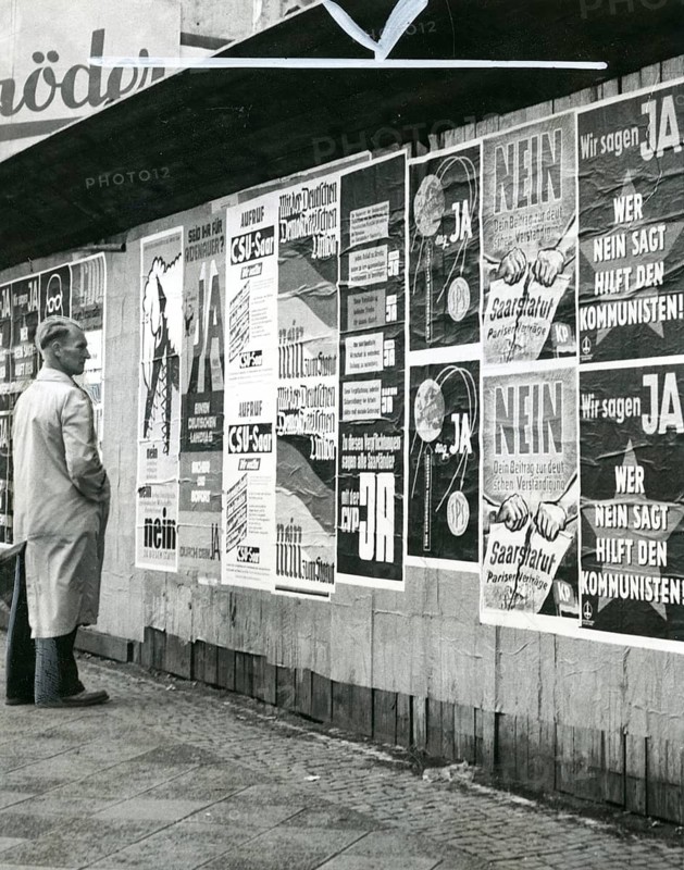 Election, Saarland, post-war period, Saar Statute, popular vote, 1957, A man looking at a wall full of political posters in black and white