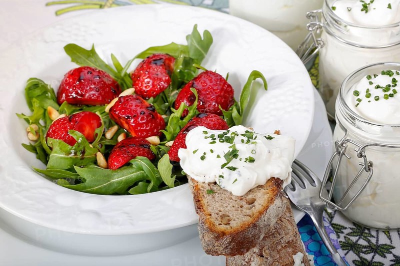 Swabian cuisine, Luggeles cheese in a jar, salad rocket with strawberries, pine nuts, Swabian cream cheese, dairy product, vegetarian, healthy, rocket, bread, chives, arranged on a plate, grandmother's kitchen, regional, home cooking, typical Swabian, traditional cuisine reinterpreted, food photography, studio, Germany