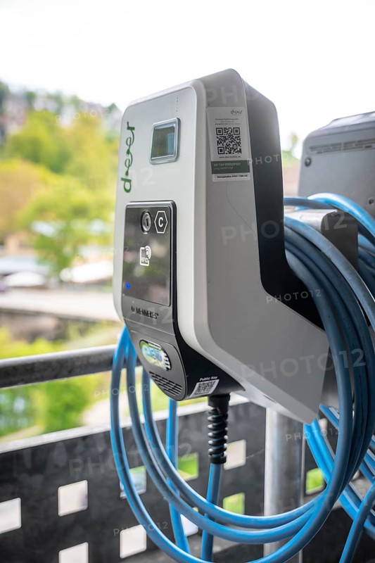 Close-up of an electric charging station with cable on a balcony with green landscape in the background, Deer charging stations, Calw, Germany
