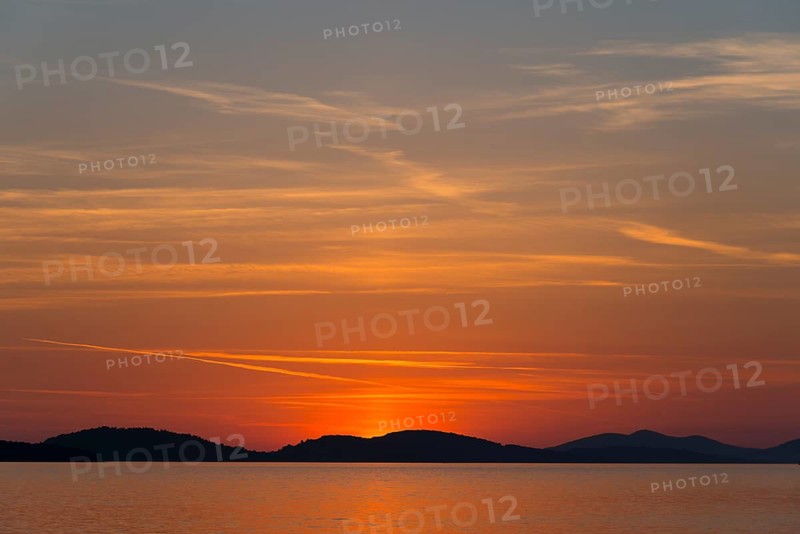 A calm sunset over the sea with orange and red coloured sky, Šibenik, Sibenik, Dalmatia, Croatia