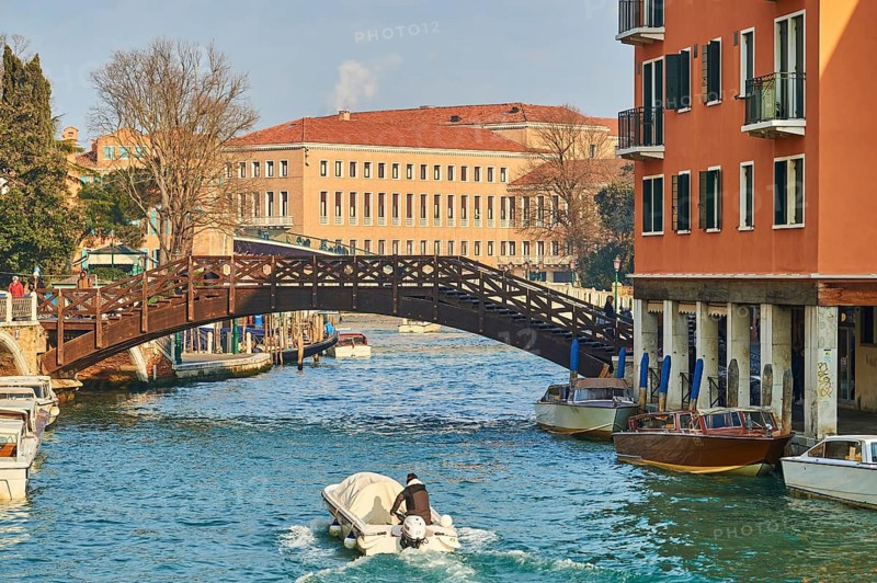 Wooden bridge going over a waterway in Venice on a sunny day in winter, Italy
