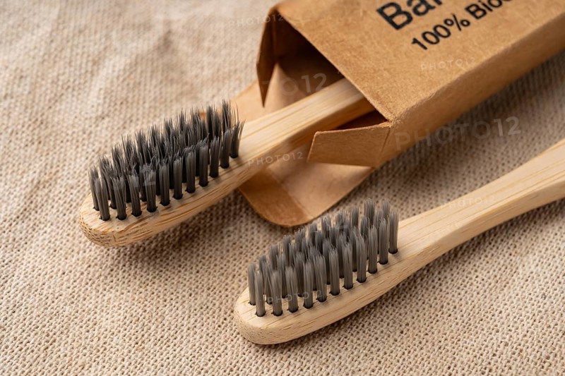 From above view of bamboo toothbrushes on a textured burlap background, showcasing eco-friendly toiletries. Features natural colors and sustainable materials for a zero waste appeal