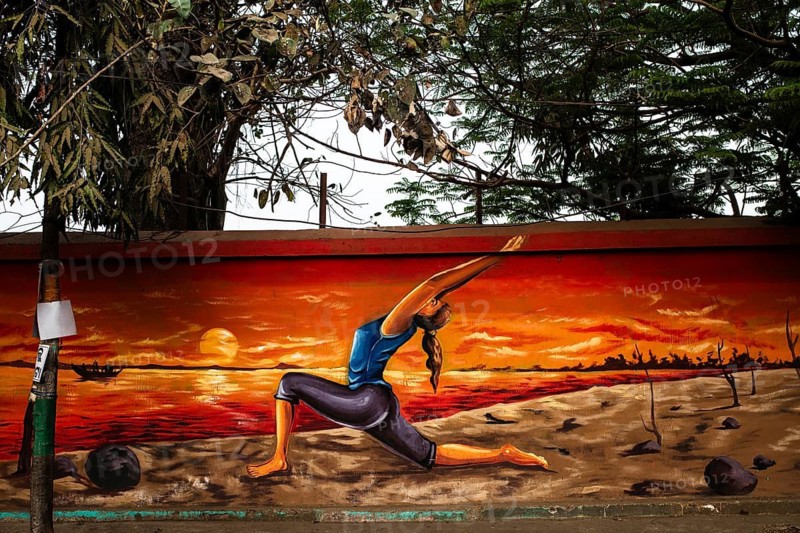 Mural painting depicting a young woman exercising on a beach (Odisha, India)