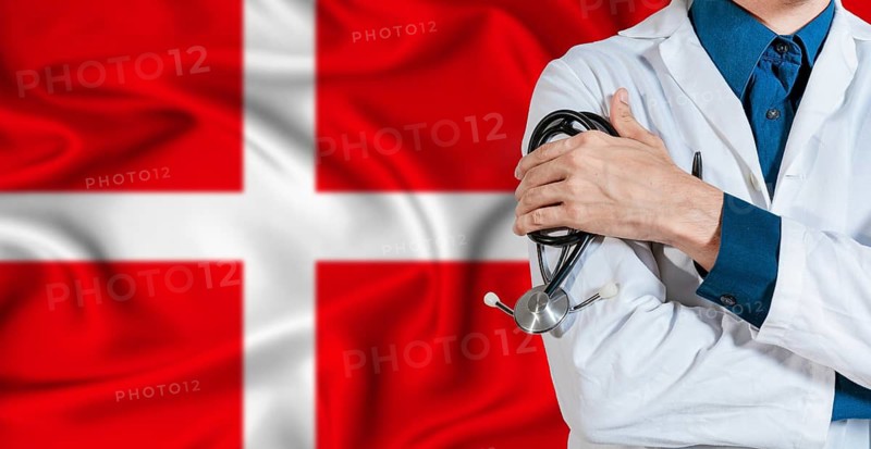 Doctor with stethoscope on Denmark flag. Doctor holding stethoscope on Denmark flag