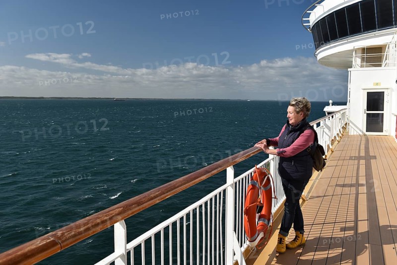 Woman standing at the railing of a ship, ferry in the Baltic Sea