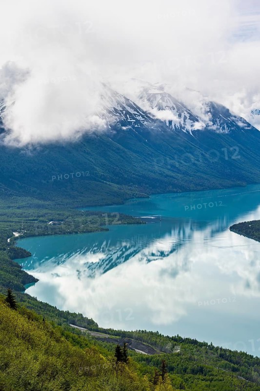View of snowy mountains in spring and turquoise Kenai Lake with reflection, Slaughter Ridge Trail, Cooper Landing, Kenai Peninsula, Alaska, USA