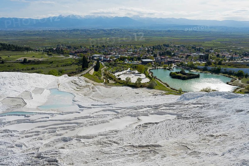 View of travertine terraces with adjacent urban landscape and mountain scenery, sinter terraces, lime sinter terraces, travertine terraces, Pamukkale, Denizli, UNESCO World Heritage Site, Anatolia, Turkey