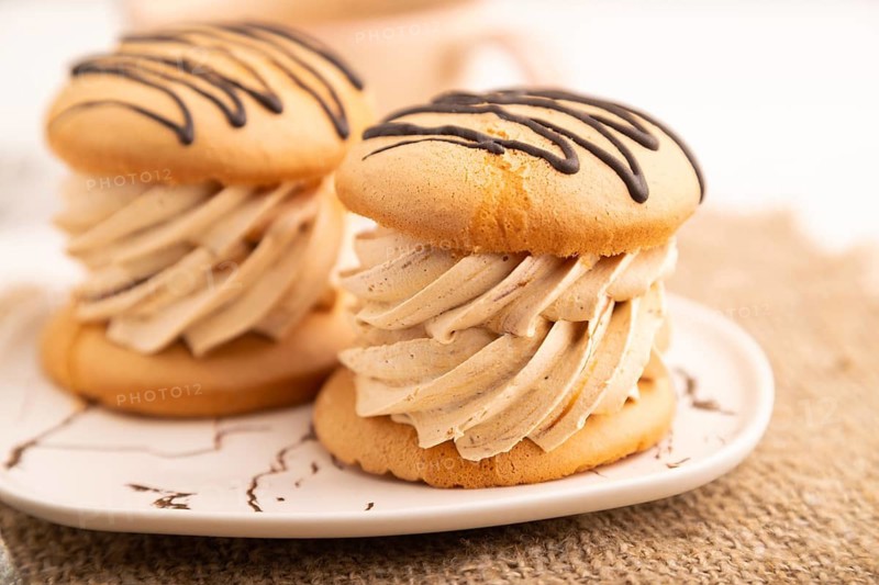 Caramel Cream Cakes on white wooden background and linen textile, cup of coffee, side view, close up, selective focus