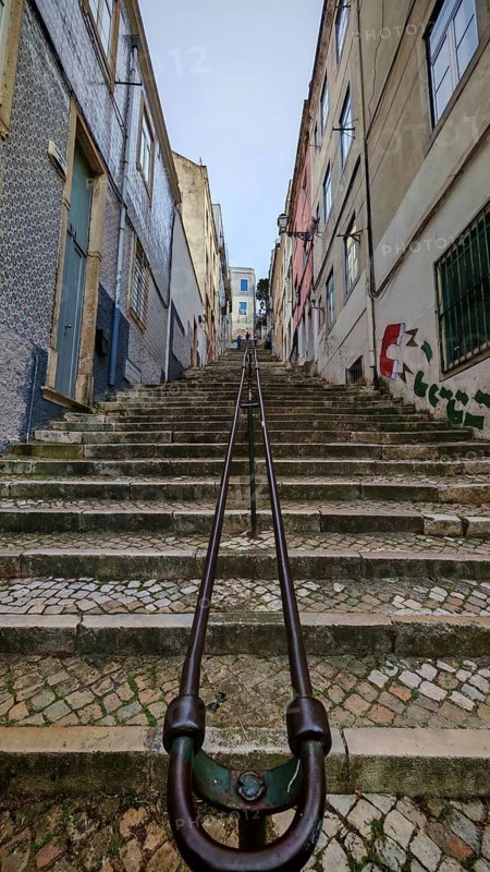Steep stone staircase in an old town flanked by buildings with small windows, Lisbon, Portugal