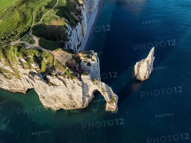 Aerial view, top-down view of the Porte d'Aval rock formation with the free-standing Aiguille d'Étretat rock pin in the morning sun, a landmark on the chalk coast with the distinctive rock gate, the viewpoint with a view over the English Channel, chalk cliffs and to the holiday resort of Étretat, Alabaster Coast, La Côte d'Albâtre, Seine-Maritime, Normandy, France