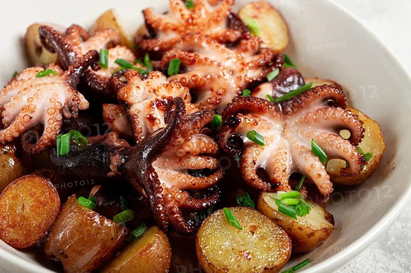 Baby grilled octopus with golden baked potatoes and fresh herbs, Maltese cuisine, homemade, no people
