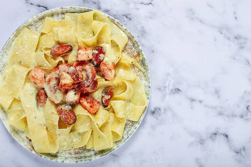 Papardelle pasta in creamy sauce with seafood, homemade, no people