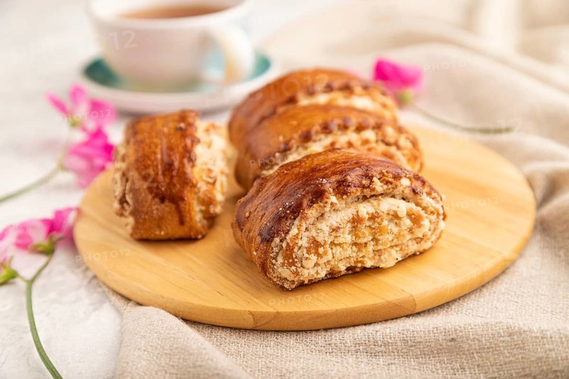 Traditional armenian dessert gata with cup of green tea on a gray concrete background and linen textile. side view, close up, selective focus