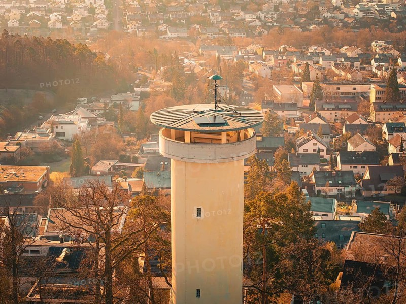 Close-up of a tower surrounded by houses and trees coloured in autumn, Böblingen, Germany