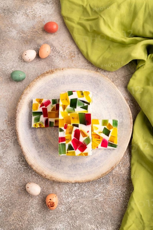 Colored Fruit and milk jelly on brown concrete background and green linen textile, top view, flat lay, close up, minimalism
