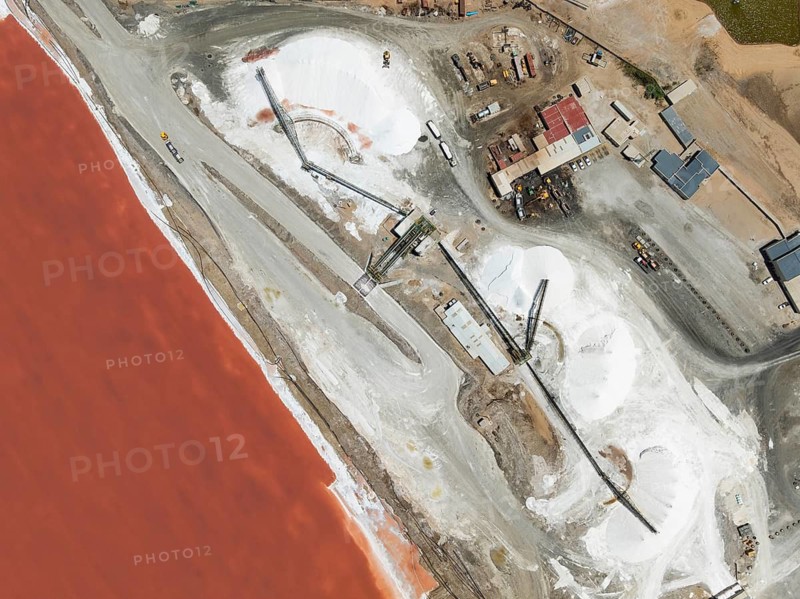 Saline pond and salt heaps at the salt works of Walvis Bay Salt. Aerial view. Drone shot. Walvis Bay, Namibia
