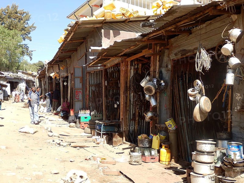 Street with huts, shops and household items on display in sunny weather, Harar, Ethiopia