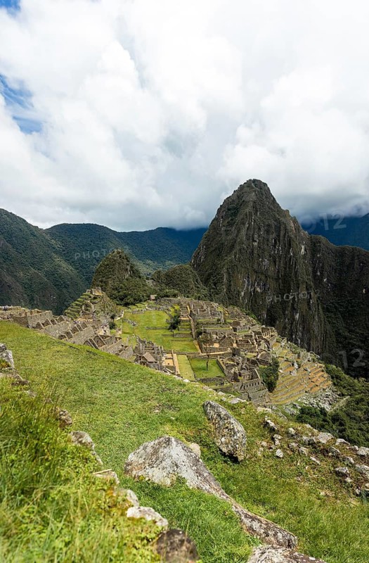 Majestic shot of Machu Picchu, with the iconic Huayna Picchu peak in the background under a cloudy sky, portraying the breathtaking scenery and historical allure of this UNESCO World Heritage site in Peru